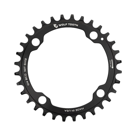 Einfach-Kettenblatt WOLF TOOTH 104 BCD 12-fach Shimano, 4-Loch, 104 mm, Schwarz — Kettenblatt auf weißem Hintergrund